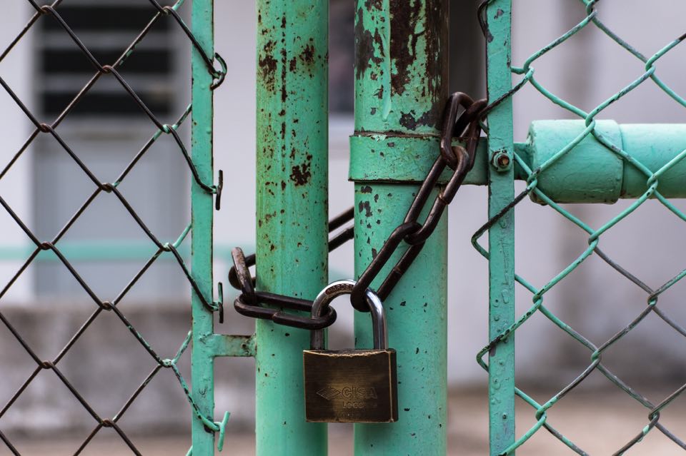 A black door is locked by a padlock and chain.