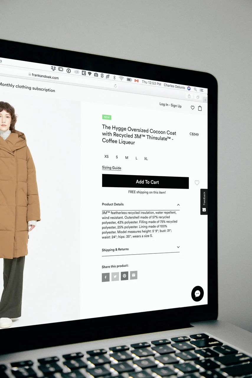 A laptop screen showing an online clothing store product page with an Add to Cart button and social share icons