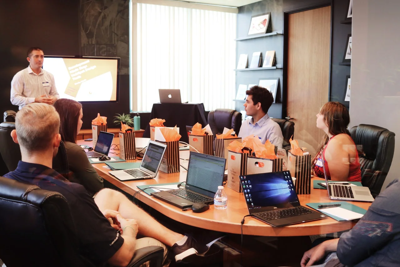 Presenter addressing colleagues seated around a conference-room table
